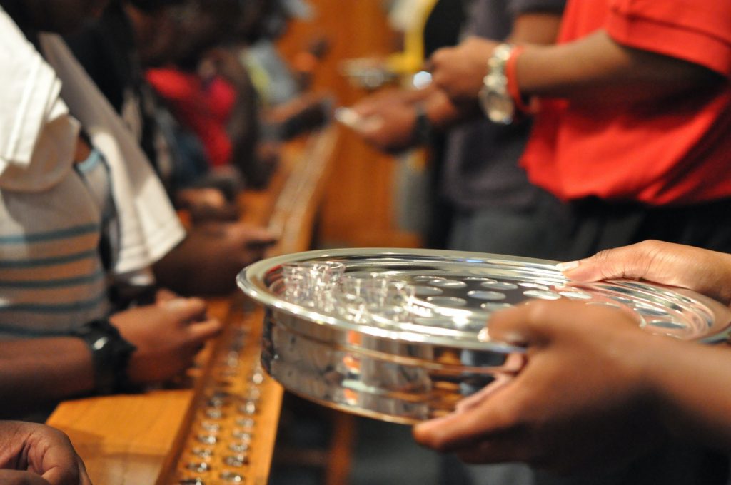 Communion using traditional single serving trays at the communion rail in an African American church